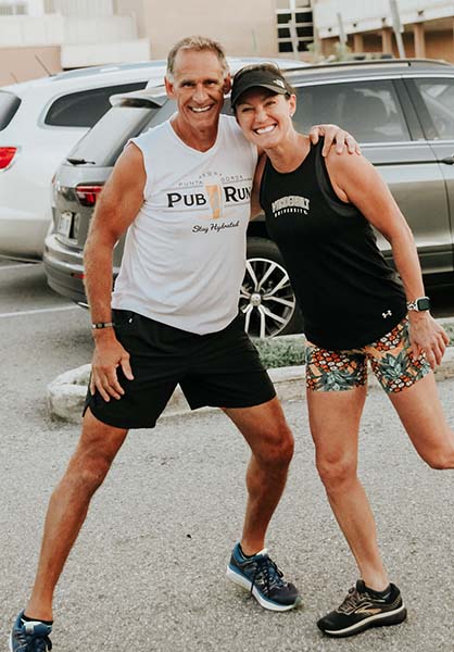 Man wearing Punta Gorda Pub Run tank top hugging another young woman Pub Runner